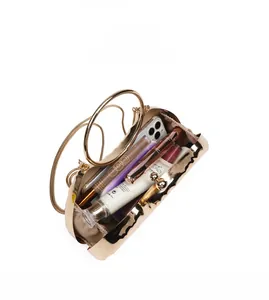 Detail showing inner capacity of a gold metallic clutch bag with wave texture and chain