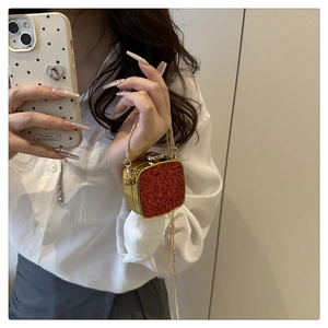 Close-up of red sequin acrylic mini box bag with gold metal frame and chain strap