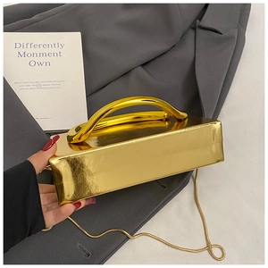 Detailed view of a gold metallic rectangular box clutch with thick handle and snake chain