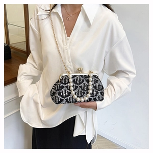 Dettaglio della pochette da sera vintage con manico di perle e catena dorata