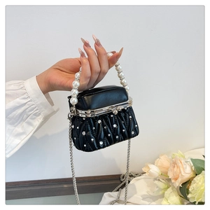 Detail of black pleated crossbody bag with sparkling rhinestones and pearl handle