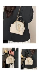 Detail of cream pearl handbag featuring gold clasp, metal handle and fringe tassel