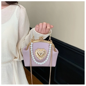 Detail of lavender pearl handbag with golden heart clasp and faux pearl handle