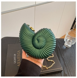 Detail of dark green snail shell acrylic clutch with spiral texture and gold chain