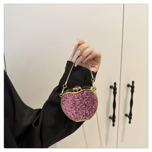Detail of heart-shaped clutch with purple sequins and gold chain handle