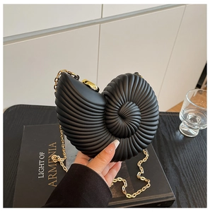 Detailed view of a matte black conch shell acrylic clutch bag with golden chain strap