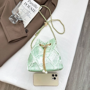 Light green quilted denim bucket bag with gold chain strap and pearl tassels