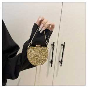 Detail of apple-shaped evening bag with gold sequins and elegant metal chain strap