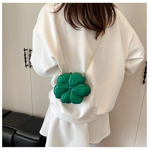 Detailed view of a green flower-shaped mini bag with a delicate gold chain strap