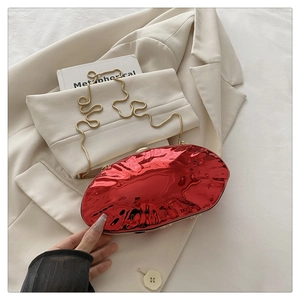 Detail of glossy burgundy oval evening clutch bag with wavy golden chain strap