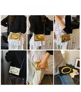 Detail of trendy acrylic box clutch with C-shaped metal handle and chain in gold and silver