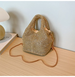 Detailed view of bucket bag with golden rhinestones, fabric handle and chain strap