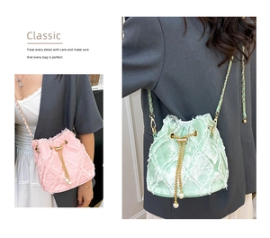 Close-up of quilted tweed bucket bag with gold chain strap and pearl charm details
