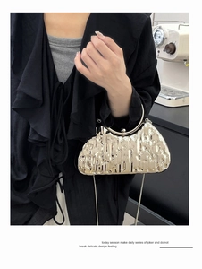 Pochette de soirée argentée à texture craquelée avec poignée en métal portée par mannequin