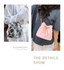 Detail of denim bucket bag with frayed edges, pearl drawstring, and chain strap