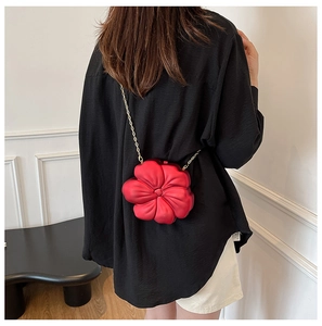 Detailed view of the 3D red flower crossbody bag with an elegant gold metal chain strap