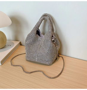 Detail of silver rhinestone bucket bag with sparkling crystals and fine chain strap