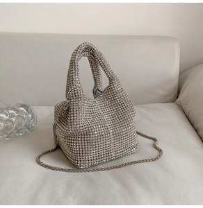 Detail of silver rhinestone bucket bag with chain strap and sparkling top handles