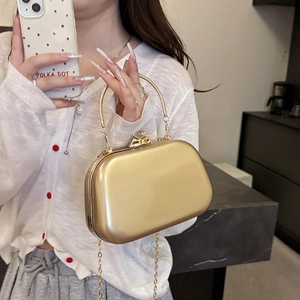 Glossy golden hard shell evening clutch with bow clasp and detachable chain strap
