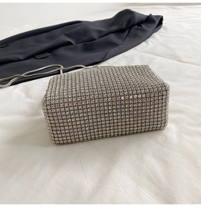 Detailed close-up of sparkling rhinestone evening bag with silver metal chain strap