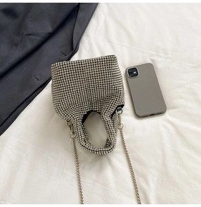 Close-up of sparkling silver rhinestone bucket bag with metal chain and handle