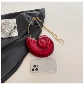 Detailed close-up of a burgundy snail-shaped shell bag with gold chain and metal clasp