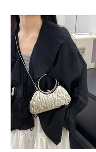 Detail of silver evening bag with ice-crack texture, metal handle and chain strap