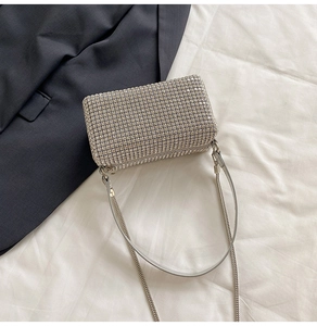 Detail of shimmering silver rhinestone mini pillow bag with chain and leather strap