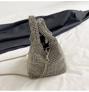 Close-up of sparkling silver rhinestones and metal chain strap on a bucket bag