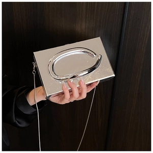 Detail of silver mirror metal box bag with large oval handle and elegant chain strap