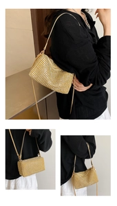 Detail showing the shiny gold rhinestone surface and fine metal chain of the shoulder bag