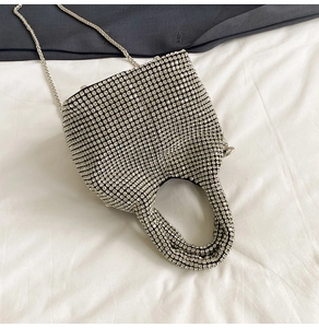 Macro detail of luxury silver rhinestone water bucket bag with shimmering metal chain strap