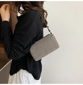 Close-up of sparkling rhinestone crossbody pillow bag worn by a model on her shoulder