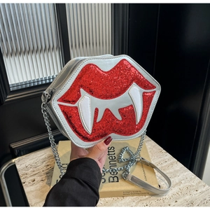 Détail du sac à bandoulière argenté avec lèvres de vampire à paillettes rouges et crocs
