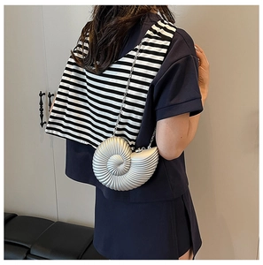 Detailed view of a silver shell-shaped acrylic clutch bag with metallic spiral textures