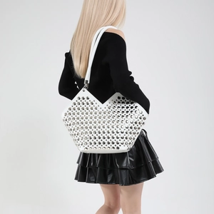 Sac seau blanc avec clous argentés et coupe en V porté par un mannequin femme