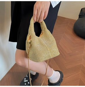 Detailed view of women's bucket bag with dense rhinestones and golden chain strap
