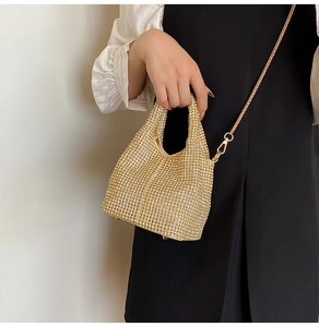 Detailed macro view of the sparkling gold rhinestone bucket bag with shiny chain strap