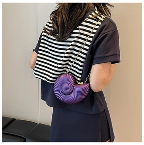 Detail view of purple seashell acrylic clutch with metallic finish and gold chain strap