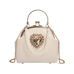 Elegant off-white pearl handle shell bag with golden heart motif and chain strap
