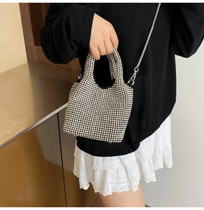 Detailed close-up of a silver rhinestone bucket bag with shiny metallic handle and chain