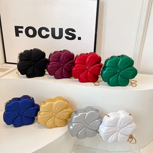 Chic 3D flower evening bags in eight colors displayed on white steps with gold chains