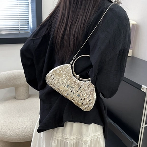 Sac à main argenté texture craquelée avec poignée ronde et chaîne sur le mannequin