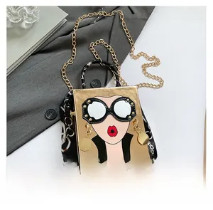 Detailed view of golden box bag with sunglasses cartoon print and scarf handle