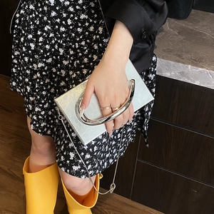 Silver metallic acrylic clutch bag with a round handle and chain strap for women