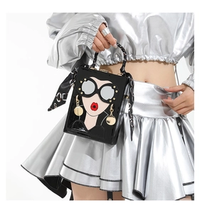 Detail of trendy box bag with fashion girl print, sunglasses element and silk scarf handle