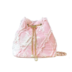 Sac seau en tweed rose avec cordon en chaîne dorée et perles sur fond blanc pur
