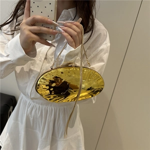 Glossy golden egg-shaped clutch bag with hammered texture and long chain strap