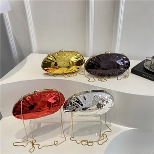 Metallic shell-shaped clutches in gold, silver and red with liquid metal texture on display