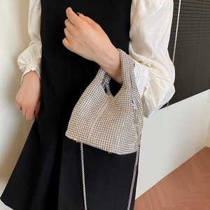 Chic silver rhinestone bucket bag with chain strap held by model for evening styling